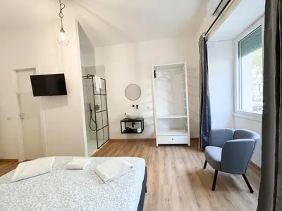 a bedroom with a bed and a chair and a window at Riboty Boutique Rooms in Rome