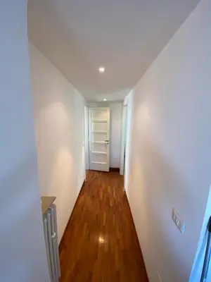 an empty hallway with white walls and wood floors at The 7th in Rome