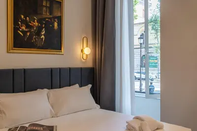 a bedroom with a bed with a painting and a window at Romart Luxury Rooms in Rome