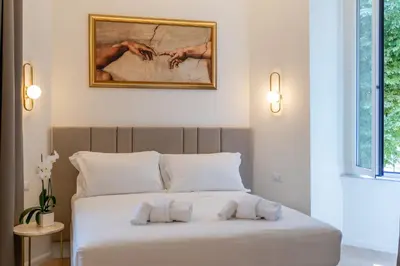 a bedroom with a bed with a painting on the wall at Romart Luxury Rooms in Rome