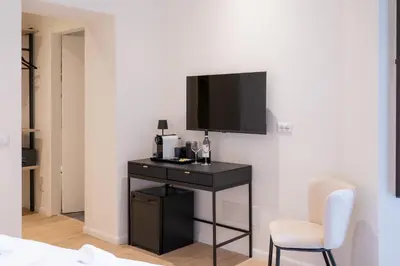 a room with a black desk with a tv on a wall at Romart Luxury Rooms in Rome