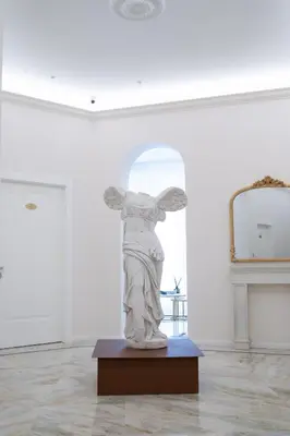 a statue of an angel in a white room at Romart Luxury Rooms in Rome