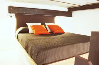 a bed with two orange pillows on top of it at Inner House in Rome