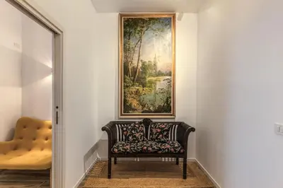 a chair in a hallway with a painting on the wall at BoHo Studio & Terrace in Rome