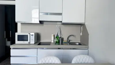 a kitchen with white cabinets and a sink and a microwave at Foro Romano Apartments C in Rome