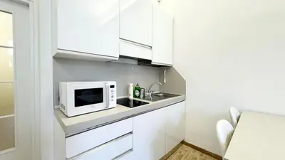 a kitchen with white cabinets and a microwave at Foro Romano Apartments C in Rome