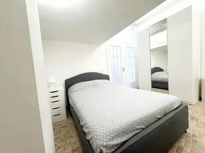 a white bedroom with a bed and a mirror at Foro Romano Apartments C in Rome