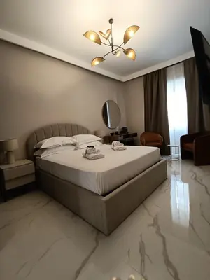 a bedroom with a large bed and a mirror at Luxury Rome Vatican's Garden in Rome