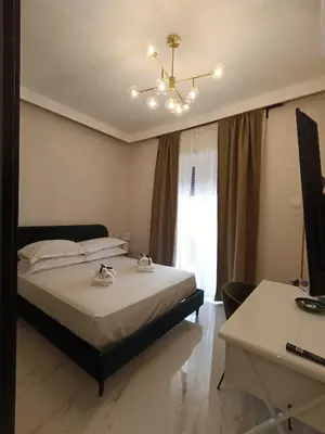 a bedroom with a bed with a chandelier and a desk at Luxury Rome Vatican's Garden in Rome