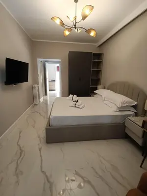 a bedroom with a bed with marble floors and a television at Luxury Rome Vatican's Garden in Rome