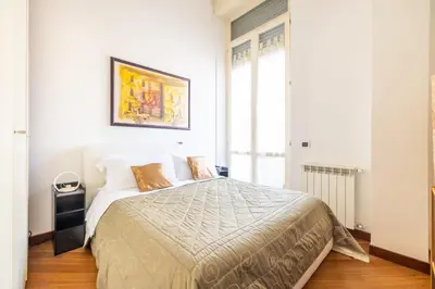 a bedroom with a large bed with white walls at Parioli Suite-duplex apartment in Rome