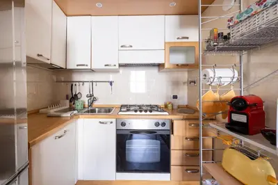 a kitchen with white cabinets and a stove top oven at Parioli Suite-duplex apartment in Rome