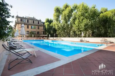 a swimming pool with lounge chairs and a building at Parioli Suite-duplex apartment in Rome