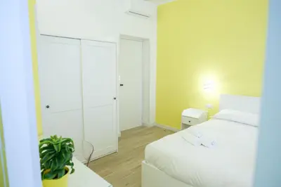 a bedroom with a white bed and a white closet at RainbHome Colourful Roman Suites in Rome