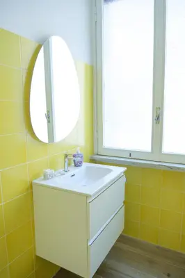 a bathroom with a white sink and a mirror at RainbHome Colourful Roman Suites in Rome