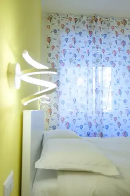 a bedroom with a bed with a curtain and a window at RainbHome Colourful Roman Suites in Rome