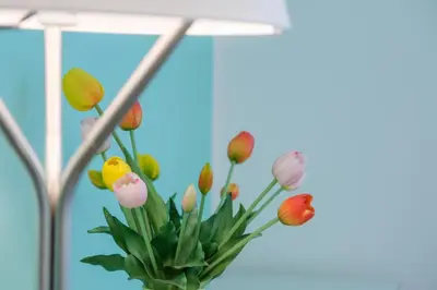 a bunch of flowers in a vase with a light at RainbHome Colourful Roman Suites in Rome