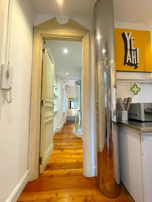 a hallway leading to a kitchen with a wooden floor at My Beauty Nest In The Historical Centre in Rome