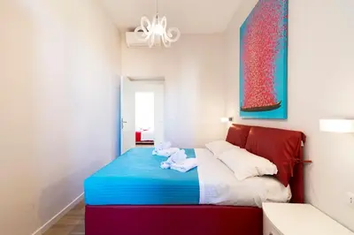 a bedroom with a blue and red bed with towels on it at Al Vaticano Roma Suite in Rome
