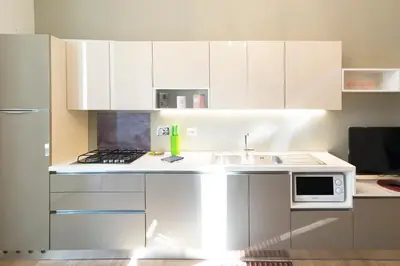 a white kitchen with a sink and a microwave at Al Vaticano Roma Suite in Rome