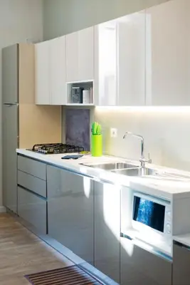 a white kitchen with a sink and a microwave at Al Vaticano Roma Suite in Rome