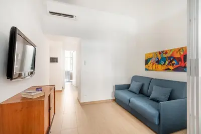 a living room with a blue couch and a tv at Alma Luxury Apartment Elegant 1BR quartiere africano Self Check in Metro B in Rome