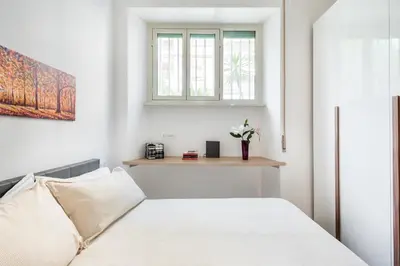 a white bedroom with a bed and a window at Alma Luxury Apartment Elegant 1BR quartiere africano Self Check in Metro B in Rome