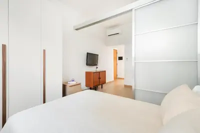 a bedroom with a white bed and a tv at Alma Luxury Apartment Elegant 1BR quartiere africano Self Check in Metro B in Rome