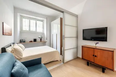 a bedroom with a bed and a flat screen tv at Alma Luxury Apartment Elegant 1BR quartiere africano Self Check in Metro B in Rome