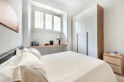 a white bedroom with a bed and a window at Alma Luxury Apartment Elegant 1BR quartiere africano Self Check in Metro B in Rome