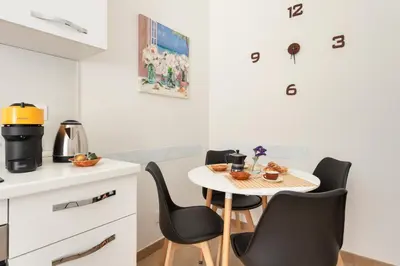 a small kitchen with a table and chairs at Alma Luxury Apartment Elegant 1BR quartiere africano Self Check in Metro B in Rome
