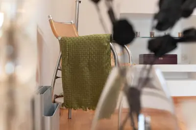 a green towel hanging on a chair at a table at San Pietro Il Campanile in Rome