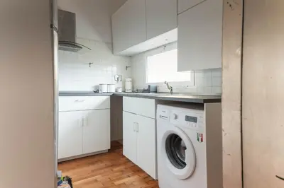 a white kitchen with a washing machine in it at San Pietro Il Campanile in Rome