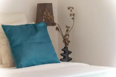 a lamp sitting on a bed next to a blue pillow at San Pietro Il Campanile in Rome