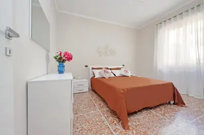 a bedroom with a bed with a blue vase with flowers at Domus 68 - Apartment with terrace in Rome