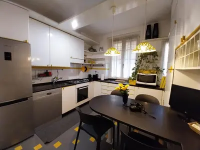 a kitchen with white cabinets and a table with chairs at Urbanflat Colosseum in Rome