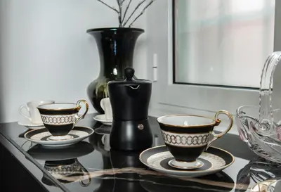 three cups and plates on a table with a vase at Suite Tacco 12 in Rome