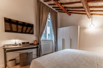 a bedroom with a bed and a desk and a window at Madama Lucrezia - Fontana di Trevi & Pantheon in Rome