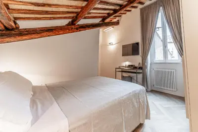 a bedroom with a white bed in a room at Madama Lucrezia - Fontana di Trevi & Pantheon in Rome