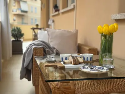 a glass coffee table with a vase of yellow flowers at Il Sogno di Balduina a 1 min Stazione Appiano-Ospedale Gemelli in Rome