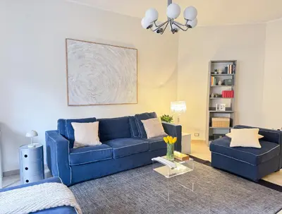 a living room with a blue couch and a table at Il Sogno di Balduina a 1 min Stazione Appiano-Ospedale Gemelli in Rome