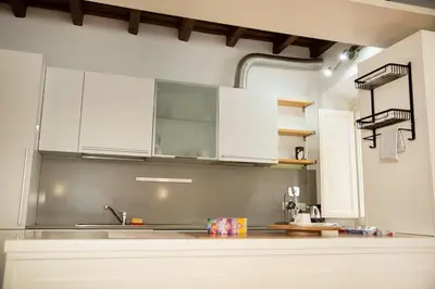 a kitchen with white cabinets and a sink at Tempietto del Carmelo in Rome