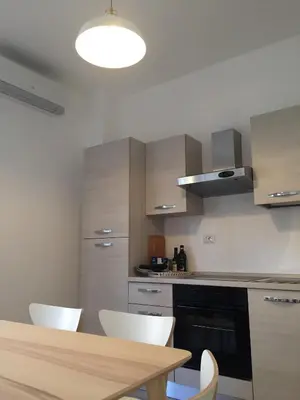 a kitchen with a wooden table and white chairs at Centro Roma Grande - LOCAPPART in Rome