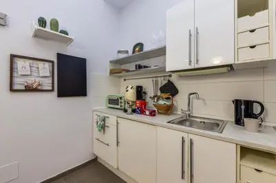 a kitchen with white cabinets and a sink at Aurora Vatican House - San Pietro in Rome