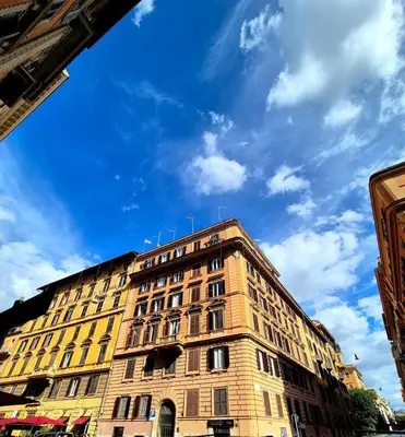 a tall building with a blue sky in the background at Aurora Vatican House - San Pietro in Rome