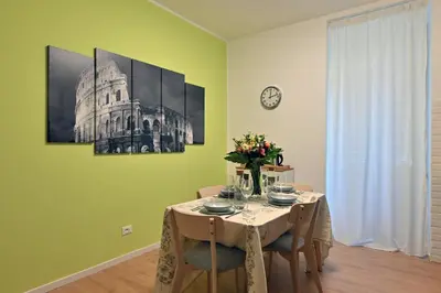 a dining room with a table and a clock on the wall at Jubilee 4 Your home in Rome Vatican in Rome