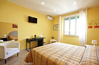 a bedroom with a bed and a chair and a window at B&B Clelia in Rome
