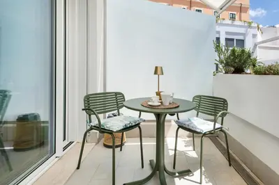 a small table and chairs on a balcony with a window at Colosseum Luxury suite 26 in Rome