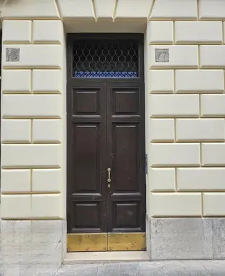a black door in a white brick building at Colosseum Luxury suite 26 in Rome