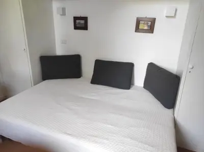 a bedroom with a white bed with two black pillows at Foro appartament in Rome